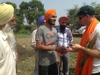 Men shaking hands in field