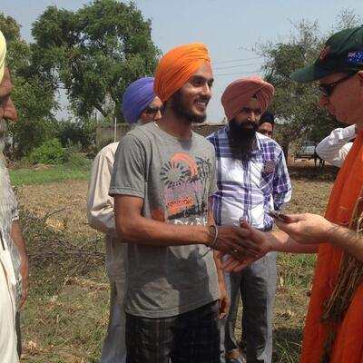 Men shaking hands in field